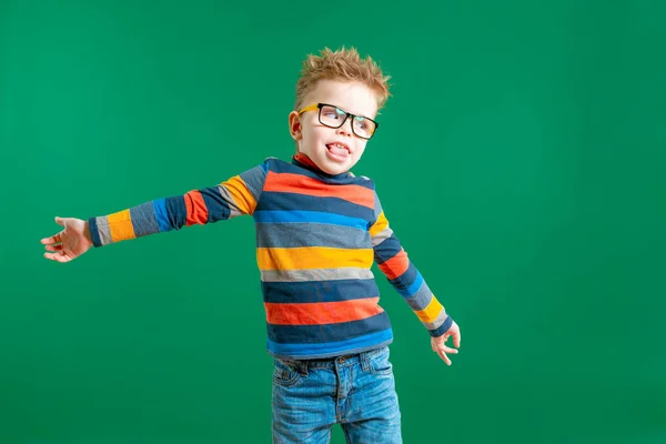 Gamine boy in glasses on a green background in the studio. Close — Stock Photo, Image