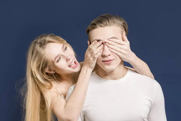 Ungt par i studion. Flickan täcker ögonen med en kille. — Stockfoto