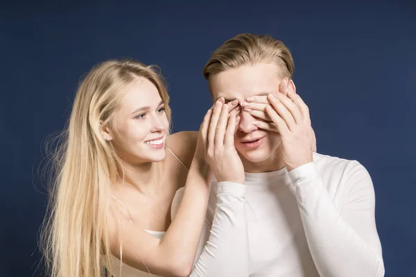 Ungt par i studion. Glad tjej stänger händerna kille. Mörka bl — Stockfoto