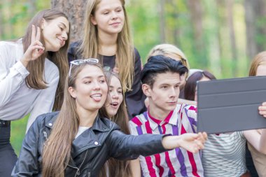 15-19 yaş arası gençler yazın tablette selfie çekiyor