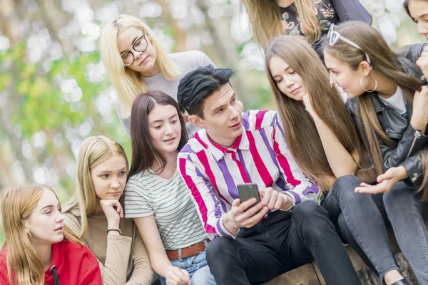 Les adolescents regardent dans le téléphone dans la forêt d'été. Gros plan . — Photo