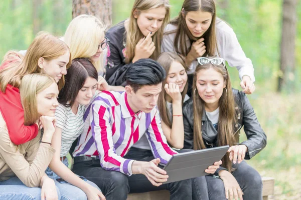 Skupina teenagerů o 15-19 let stará se dívá na tabletu v — Stock fotografie