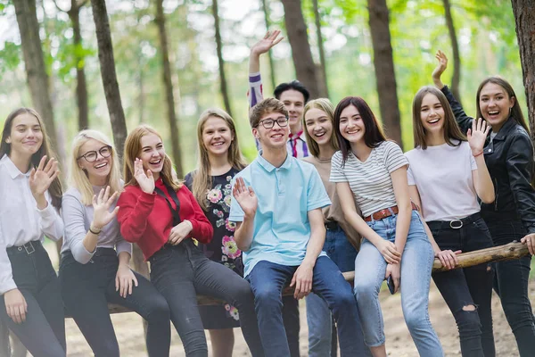 Десять смішних підлітків віком 15-19 років сидять на промені — стокове фото