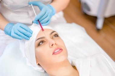 Kozmetoloji. Bir Kozmetolog bir enjeksiyon prosedürü gerçekleştirir. Kozmetoloji Kliniği