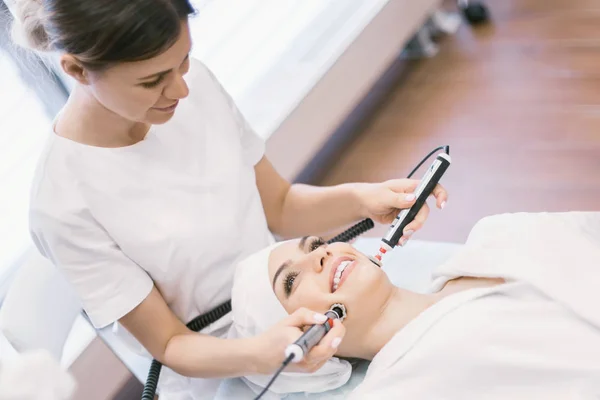 Bir Kozmetolog cilt tonunu geliştirmek için bir prosedür gerçekleştirir, yüz germe. Kozmetoloji Kliniği. Tıbbi donatım