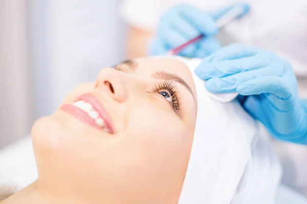 Cosmetology. Smiling girl on injection procedure. Cosmetology clinic