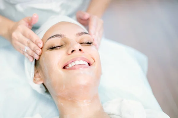 Maske ile masaj yaparken Kozmetolog elleri yakın. Yüz tedavisi. Spa prosedürü