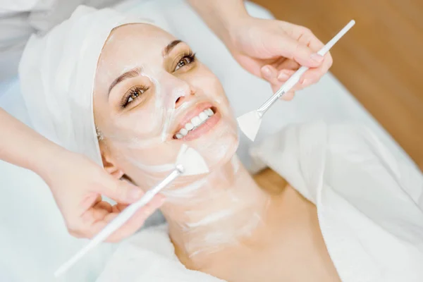 Cosmetology Cosmetologist Applies Cleansing Face Mask Two Brushes Smiling Girl — Stock Photo, Image