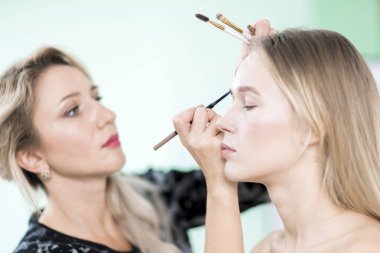 Stüdyoda makyaj. Makyaj sanatçısı kaşları çizer