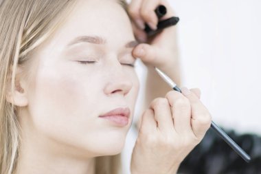 Makyaj sanatçısı göz gölgesi uygular. Makyaj yakın çekim