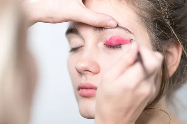 Performing makeup. Applying a bright makeup for eyeshadow