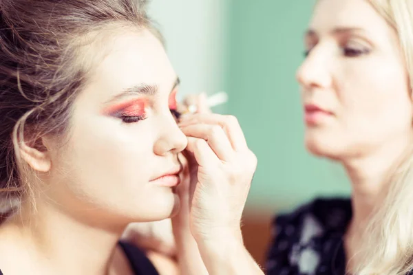 Bright makeup. Makeup artist performs makeup closeup