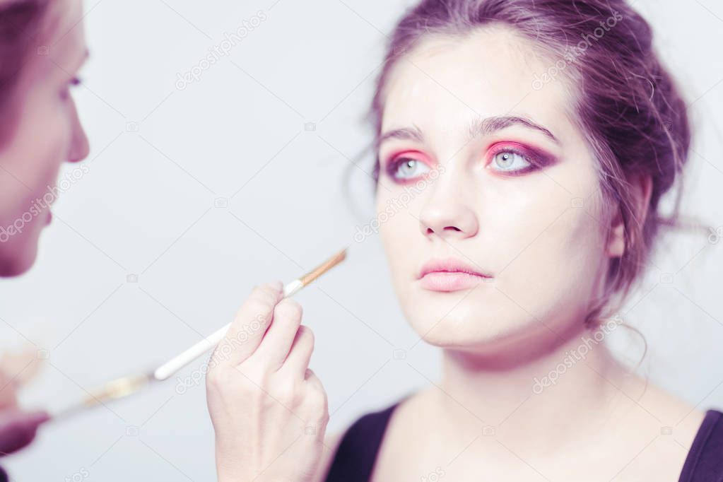 Makeup. Performing bright makeup close-up. Expressive look