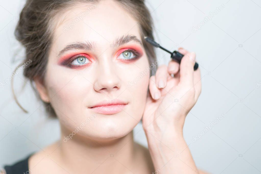 Bright makeup. Makeup artist applies mascara. Close-up