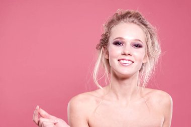 Stüdyoda parlak bir arka planda çıplak omuzları ile gülümseyen kız. Close