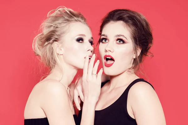 Twee Mooie Meisjes Fluisteren Een Rode Achtergrond Studio — Stockfoto