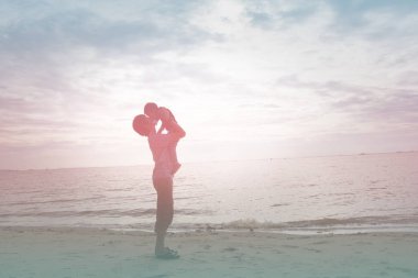 Baba ve oğul sahilde günbatımı anda oynamak. Dostu aile kavramı.