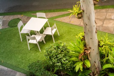 Yağmur sonrası masa ve sandalyelerle bahçe verandası