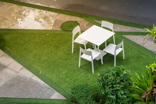 Yağmur sonrası masa ve sandalyelerle bahçe verandası — Stok fotoğraf