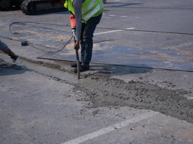 Müteahhitler konut cadde yükseltme sırasında çimento dökme.