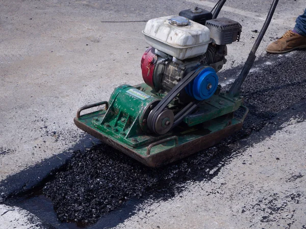 Werknemer gebruik trilplaat Compactor verdiacteren asfalt op weg — Stockfoto