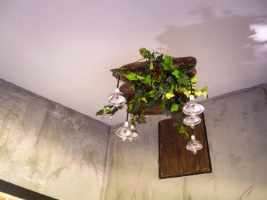 Klasik tarzda asılmış tavan lambası sıcak turuncu ton açık renk beton arka plan duvarı