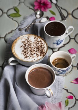 Kahve kahve, espresso, sıcak çikolata ve tatlı bir antika masa ve gümüş tepsiler ve eski kaşık arka plan üzerinde