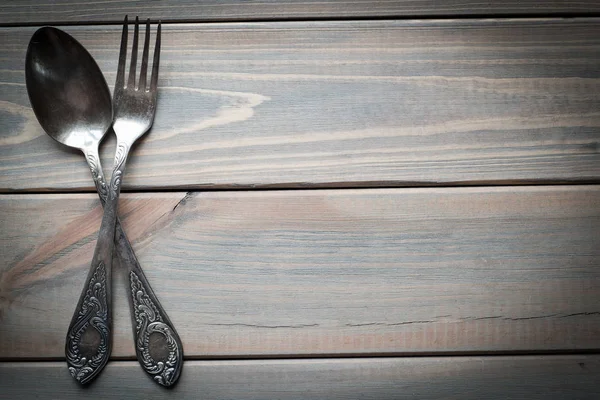 Vintage silver spoon and fork on a wooden background. Kitchen utensils. Free copy space.