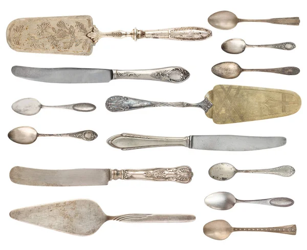 Vintage metal antique spoons, knives, shovels for cake isolated on a white background. Retro silverware.