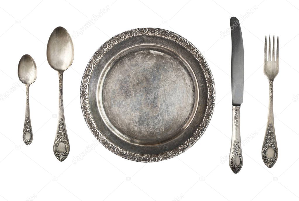 Vintage metal antique plate, spoon and fork isolated on a white background. Retro silverware.