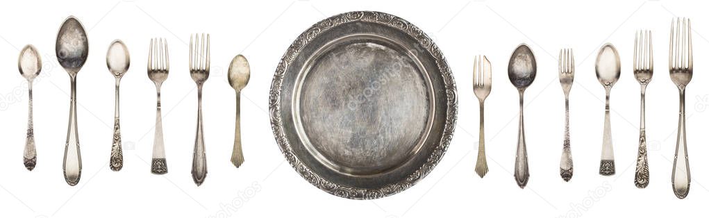 Vintage metal antique plate, spoon and fork isolated on a white background. Retro silverware.