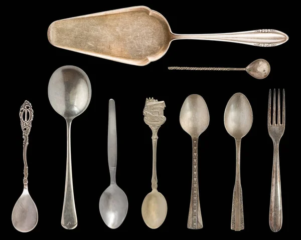 Vintage Silverware, antique spoons, knives, cake shovels isolated on isolated black background. Antique silverware. Retro.