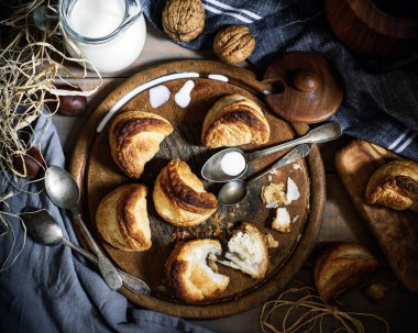 Yunan peynir süt vintage kaşıklar, yakınındaki eski tahta üzerinde puffs, 