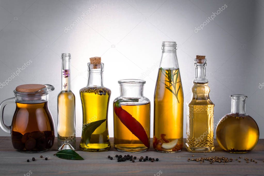 Oil in bottles with butter, olive oil with herbs and spices on t