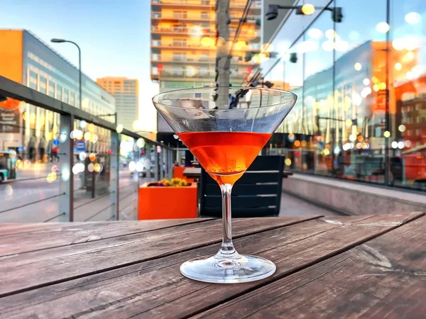 city blurred light in buildings window and  street cafe glass of orange cocktail on table top  lifestyle restaurant modern architecture Tallinn urban background