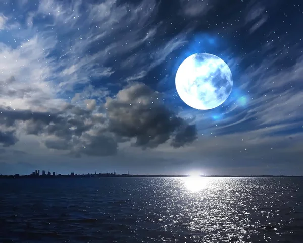 full moon on cloudy fluffy dark night starry sky at sea and moonlight reflection on water on horizon city silhouette nature landscape
