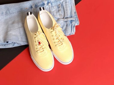 Kadınlar için kırmızı siyah arka planda spor ayakkabılar ve kot pantolon yaz sezonu moda sporu ve dinlenme zamanı 