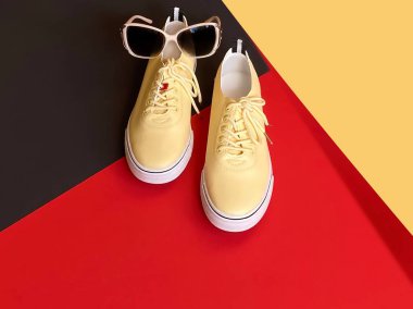 Kadınlar için spor ayakkabıları ve güneş gözlüğü kırmızı sarı arka plan ayakkabıları yaz sezonu moda sporu ve dinlenme zamanı