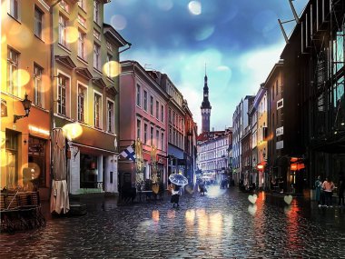 Tallinn 'in yağmurlu eski kasabasında insanlar şemsiyelerle yürüyor. Ortaçağ şehir gecesi asfalt yaşam tarzını bulanıklaştırıyor. 