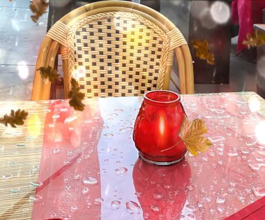 Sonbahar yaprakları cam şehir kafe masasına yağmur damlaları ve kırmızı camlı sandalye yağmurlu mevsim hava tahminleri arka planında