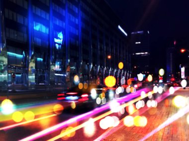 Şehir gecesi neon ışıklı arabaları bulanıklaştırdı ve gece renkli camlar modern binalar cadde üzerinde kırmızı sarı şehir yaşam tarzı 