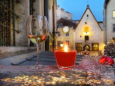 Tallinn 'deki Noel süslemeleri Avrupa' da Estonya 'da ortaçağ seyahat tatilinde kırmızı mum ışığında şampanya camları bulanıklaştı. 