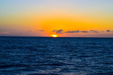 Karayipler 'deki Aruba adasındaki Kartal Sahili' nde gün batımı, mavi sularda büyüleyici renkler.