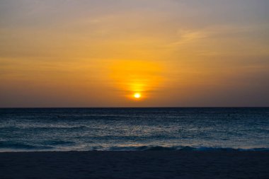 Karayipler 'deki Aruba adasındaki Kartal Sahili' nde gün batımı, mavi sularda büyüleyici renkler.