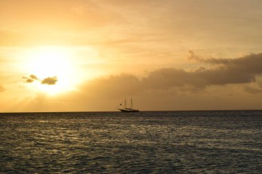 Aruba 'nın beyaz plajında turkuaz suyla güzel altın gün batımı.