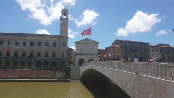 ピサの赤い旗は イタリアのトスカーナ州ピサ市中心部のアルノ川の橋 Ponte Mezzo の上の風によって動かされました — ストック動画
