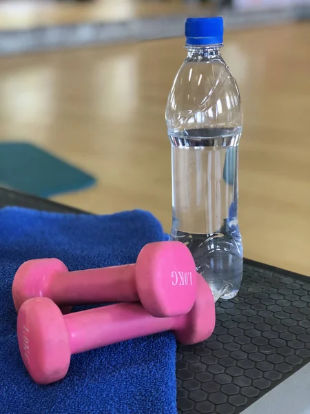 Sports tools and a bottle of water on the floor in the gym.