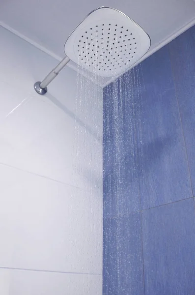 Douchekop Met Stromend Water Achtergrond Van Witte Blauwe Tegels — Stockfoto