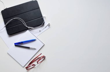 Beyaz Resepsiyon Masa tablet, smartphone, Gözlük, kulaklık, Not defteri ve kalem. Üstten görünüm kopya alanı, düz ile yatıyordu. 