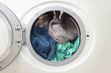 Çamaşır makinesi ile açık kapı ve renkli elbise ile yüklendi. Görüntü